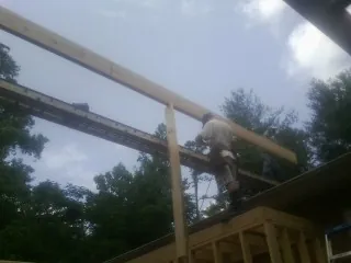 Carpenter setting a ridge beam over a new addition frame — Ice Dam Removal by Roofing Brothers in Muenster