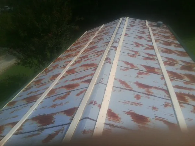 Rusted metal roof panels with new wood purlins before replacement — Storm Damage Roof Repair in Muenster by Roofing Brothers