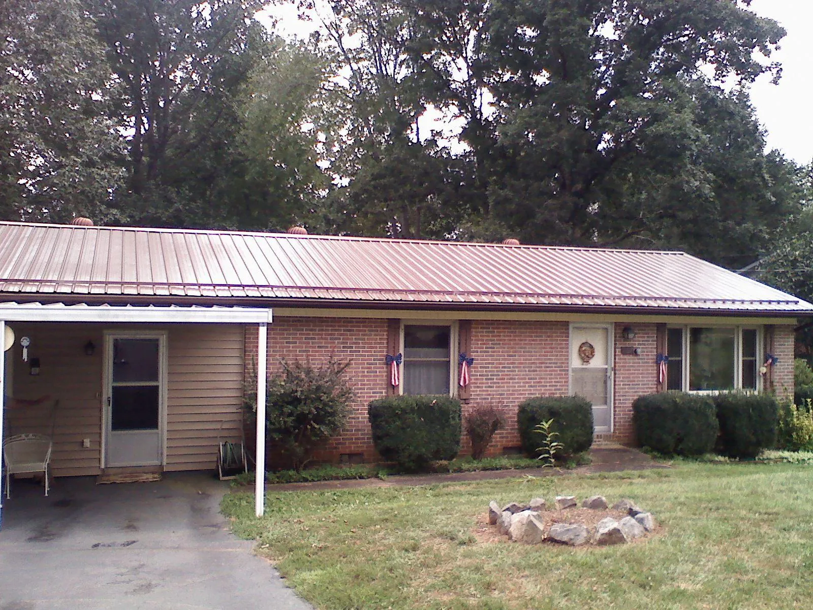 Bronze metal roof and carport on a brick ranch home — Roof Repair work by our crew in Muenster